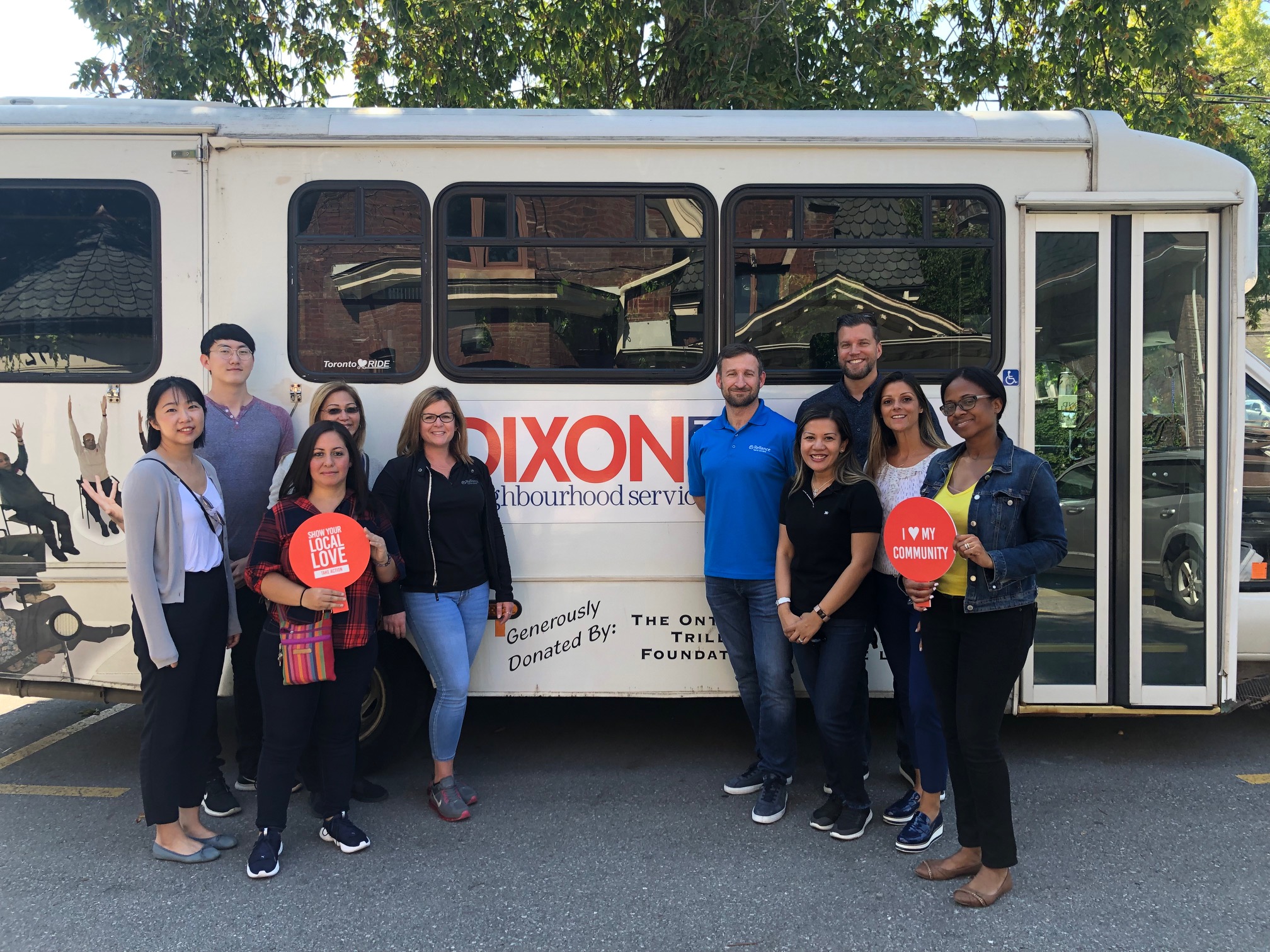 volunteers pose in front of the meals on wheels delivery bus