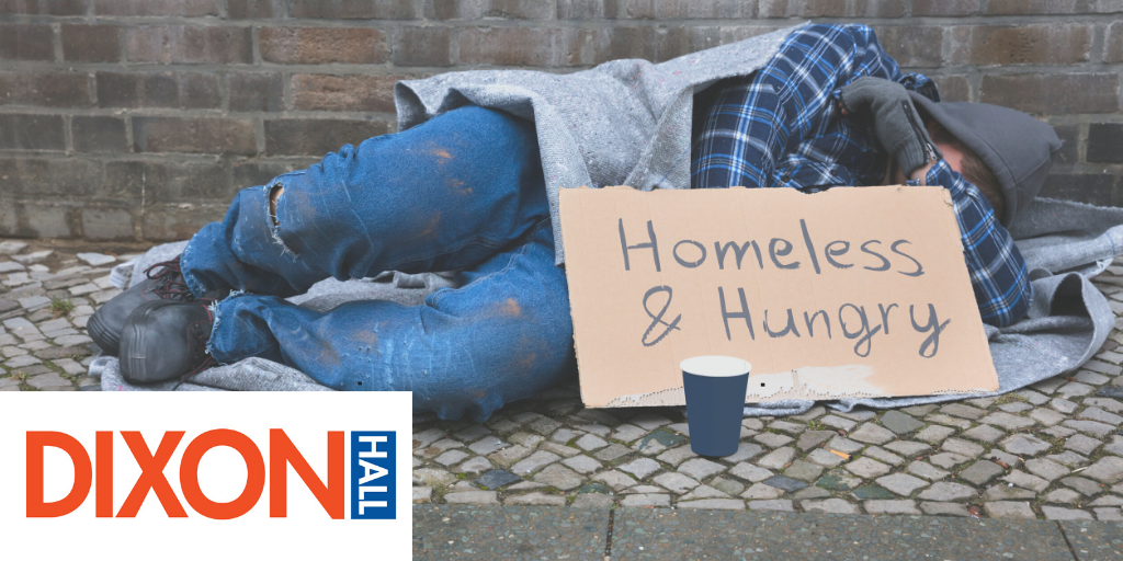 Man lying on street with Homeless & Hungry sign